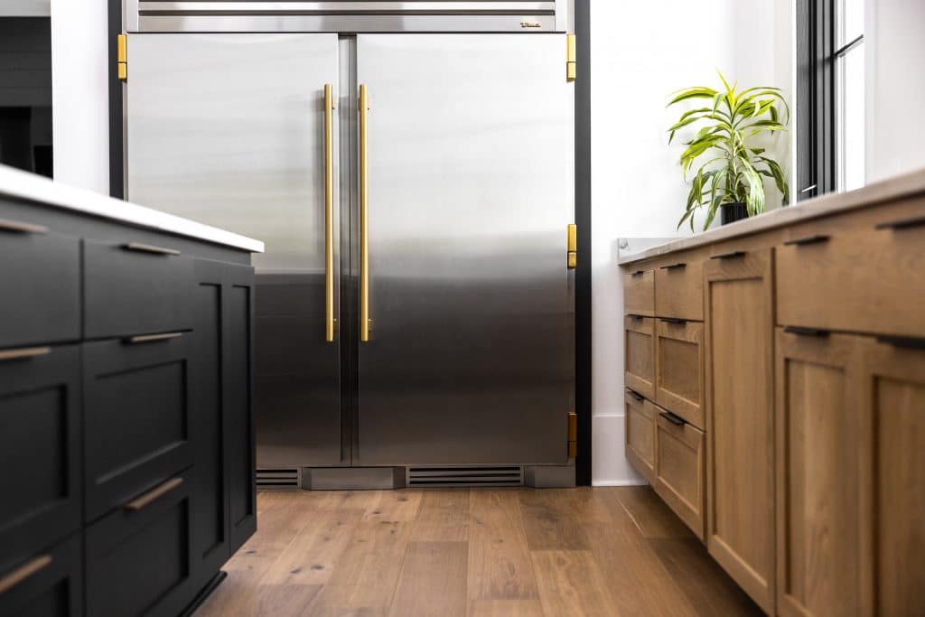 Stainless Steel Refrigerator and Freezer with Black Island Countertop and Brown Counters